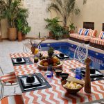 Table du petit-déjeuner installée face à la piscine du patio