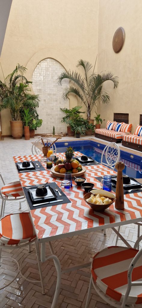 Table du petit-déjeuner dressée au bord de la piscine du Riad BabMoon