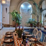Table dressée au bord de la piscine pour un dîner au Riad Babmoon