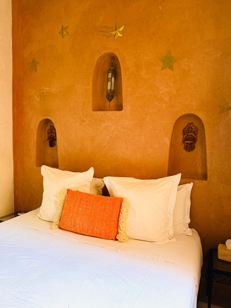 Suite Comète du Riad Babmoon : murs ocre, niches sculptées et étoiles peintes
